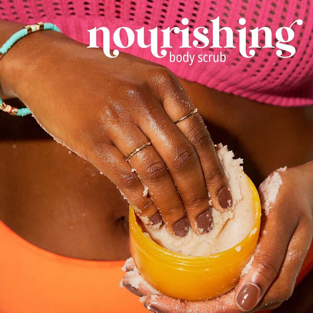 Person using a yellow container of body scrub with 'nourishing' text above.