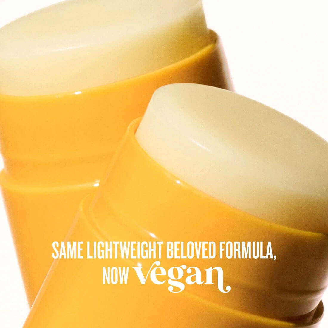 Two yellow skincare products with text indicating a vegan formula on a white background