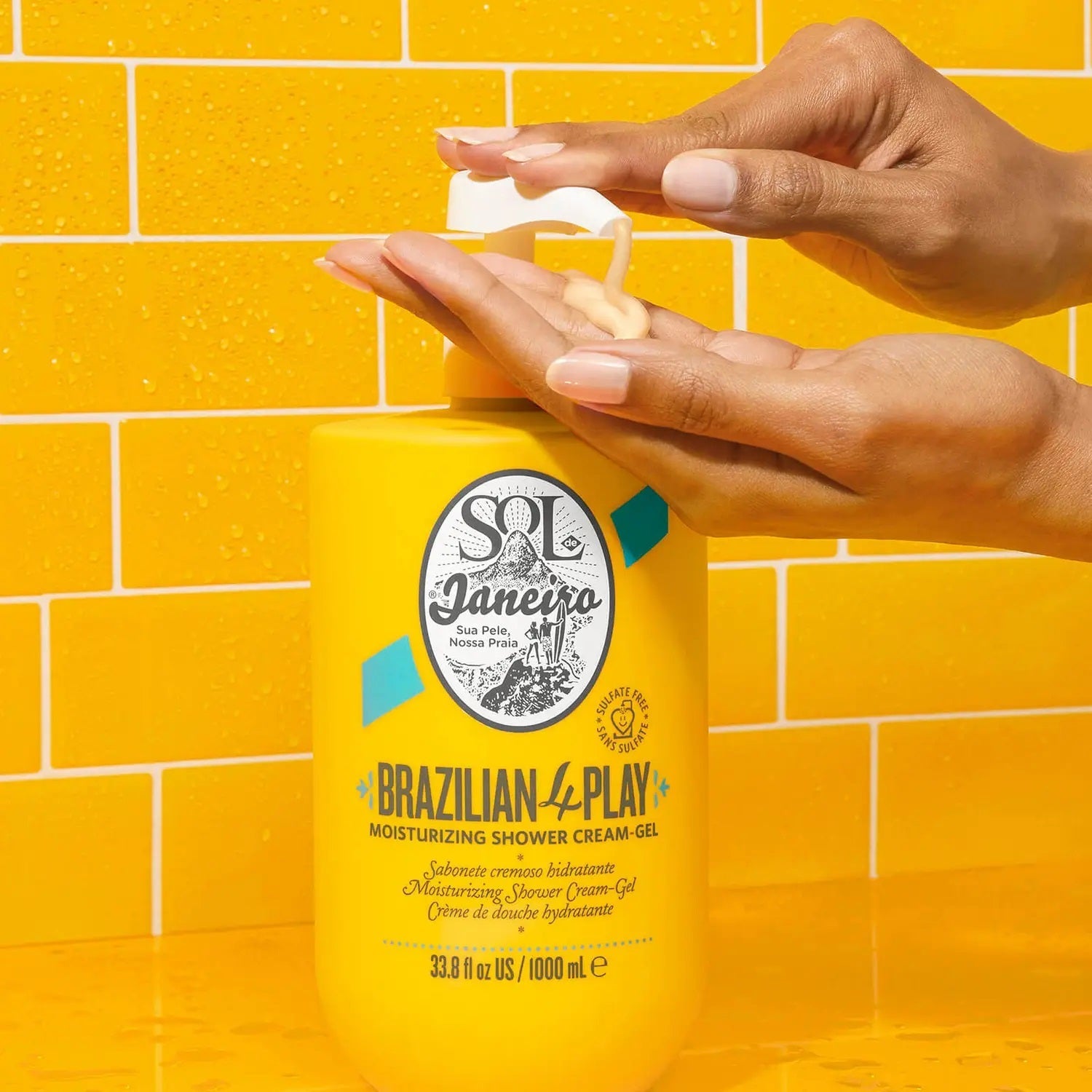 Person applying Sol de Janeiro shower cream-gel on a yellow tiled background