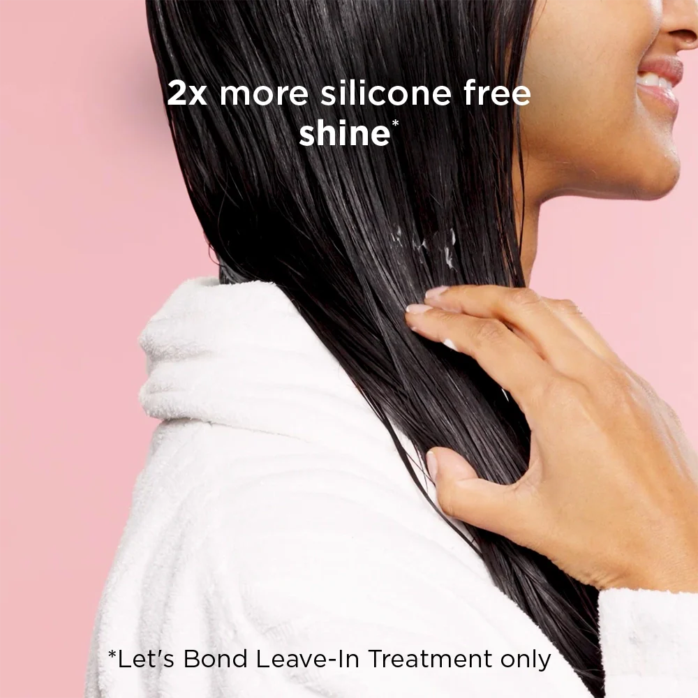 Woman with long, straight hair holding it with a text overlay about silicone-free shine.