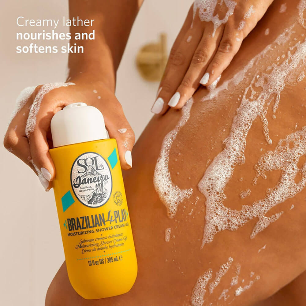 Person applying a shower cream labeled 'SOL de Janeiro' to their skin with visible foam.