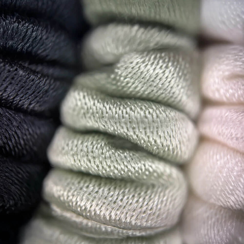 Close-up of textured fabric in black, beige, and pink.