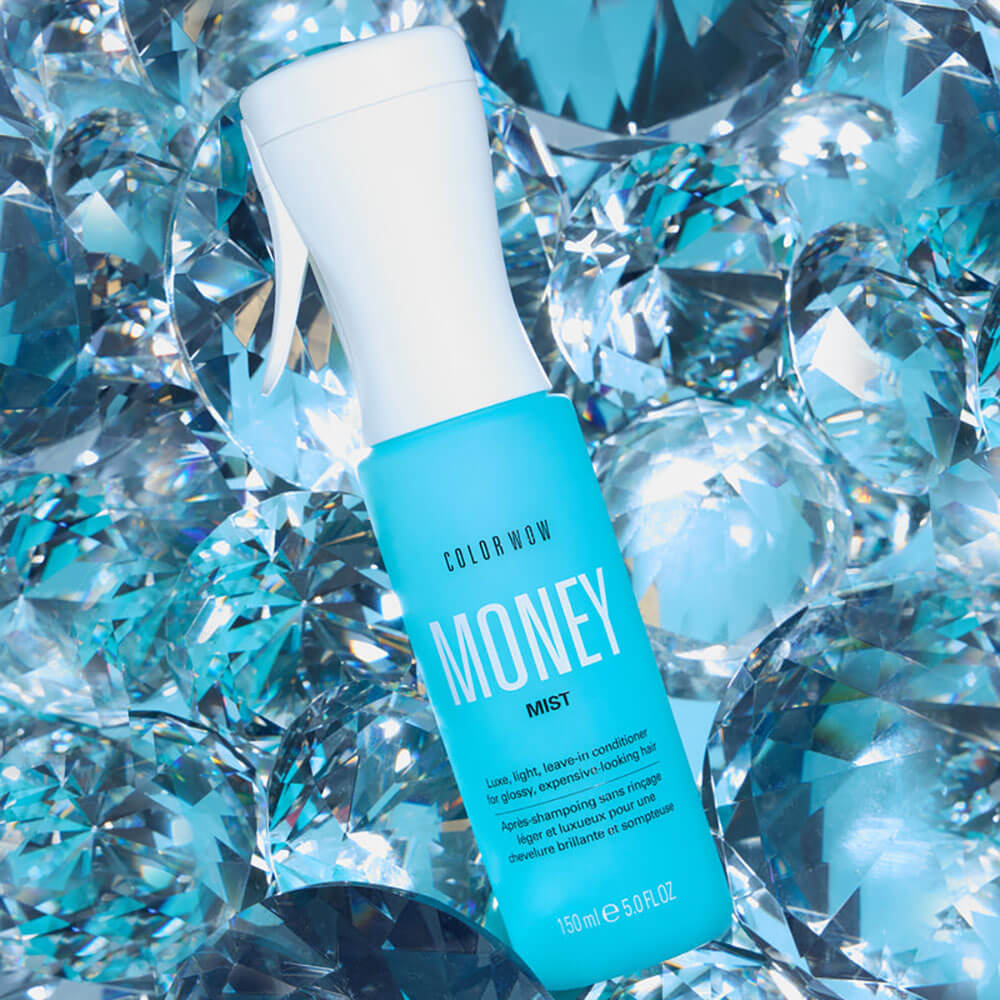 Color Wow Money Mist bottle on a blue gemstone background