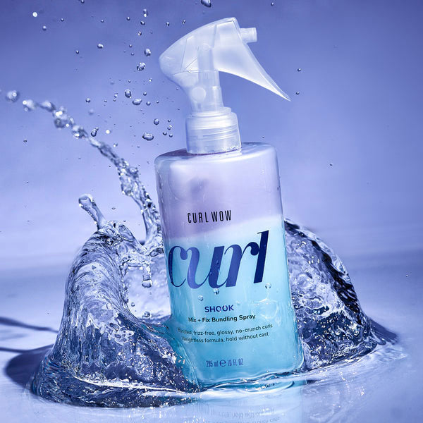 Curl Wow Curl Shock spray bottle with water splash on a blue background