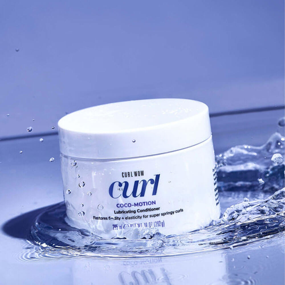 Jar of Curl Wow Coco-Motion conditioner with water droplets on a blue background