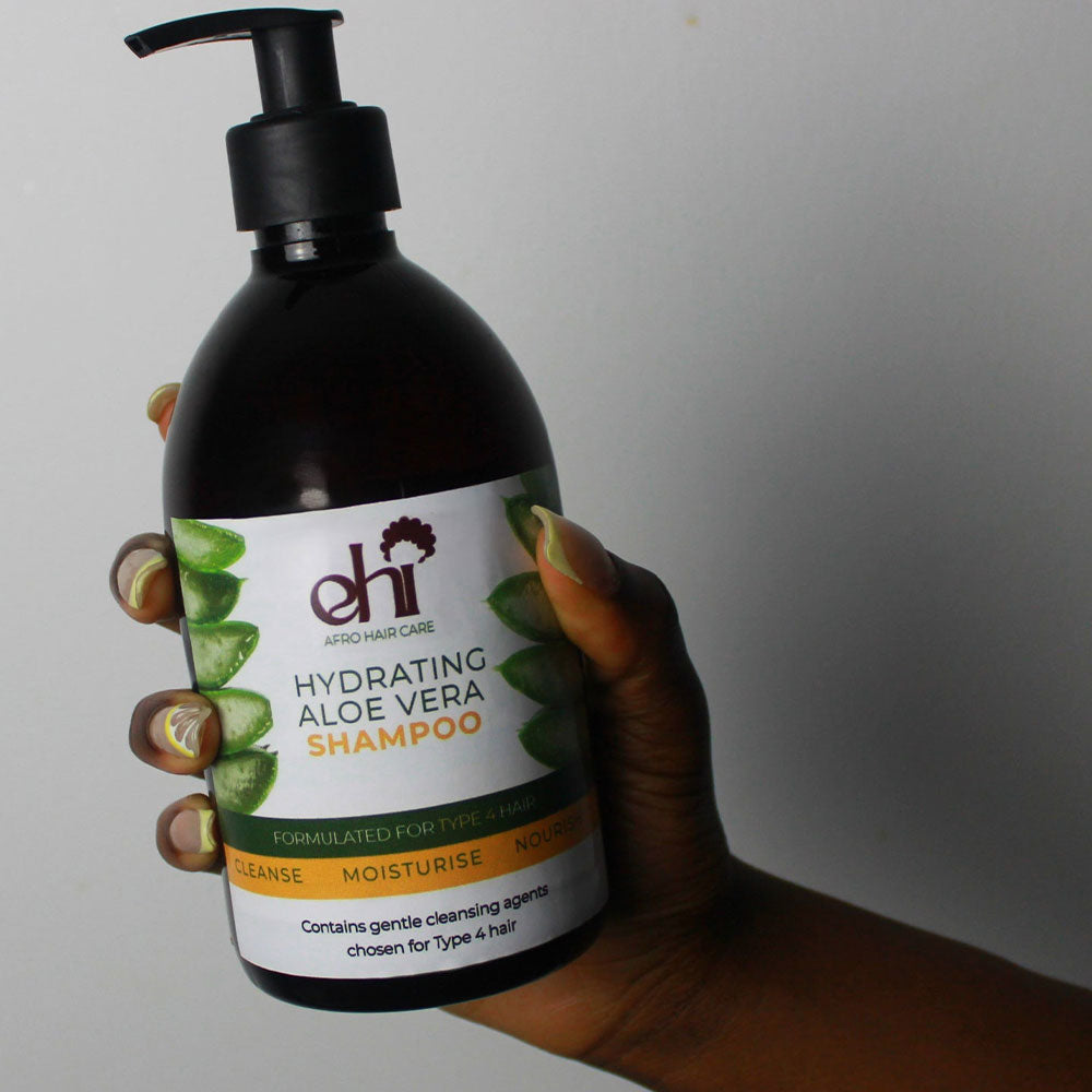 Hand holding a bottle of 'eHi' Hydrating Aloe Vera Shampoo against a plain background