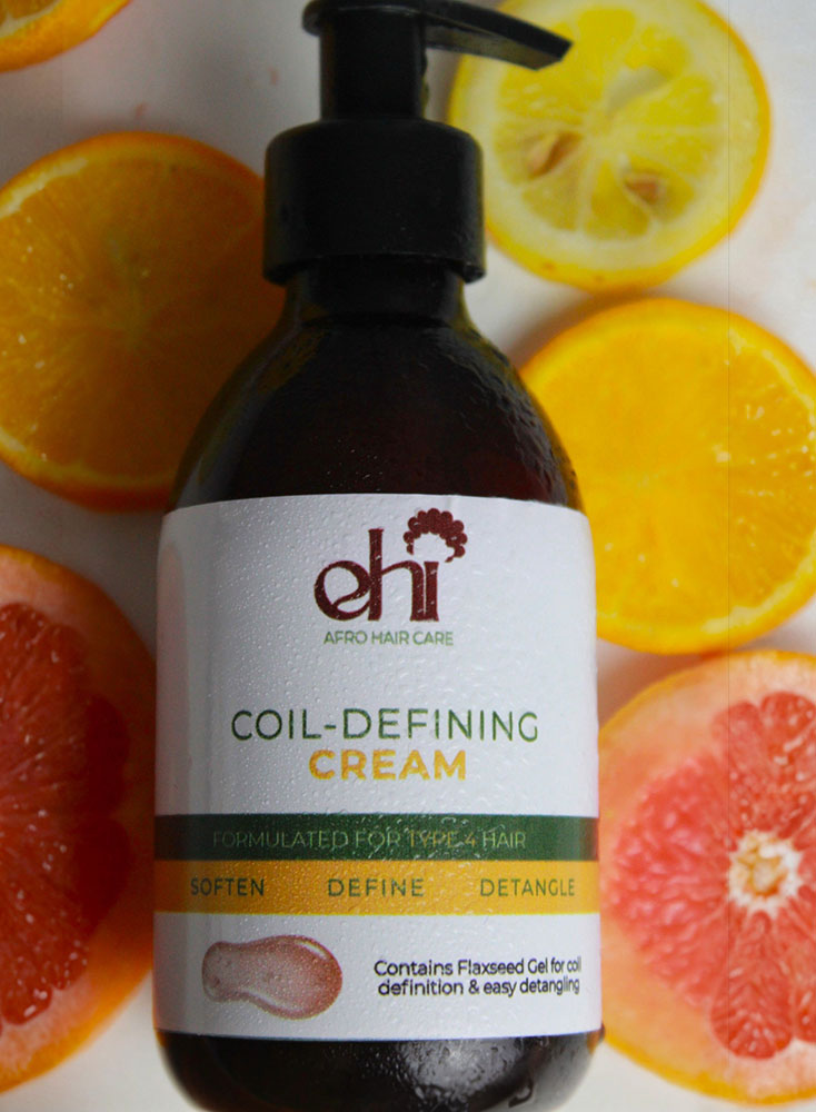 Bottle of 'ehi' coil-defining cream with citrus fruits in the background