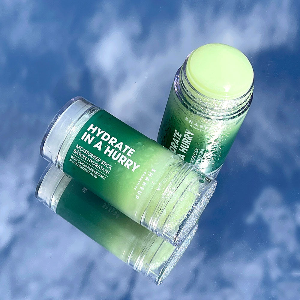 Two green skincare sticks with a blue background