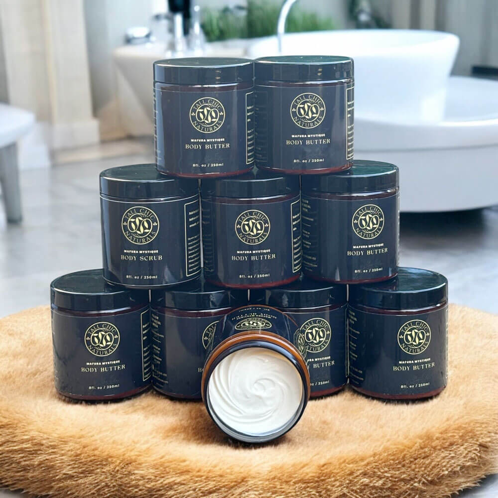 Stack of body butter jars with one jar open showing cream on a textured surface.
