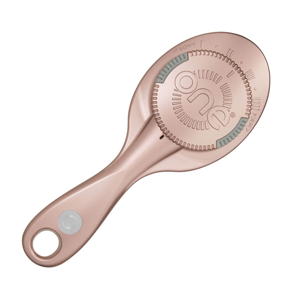 Rose gold hairbrush with brand logo on a white background