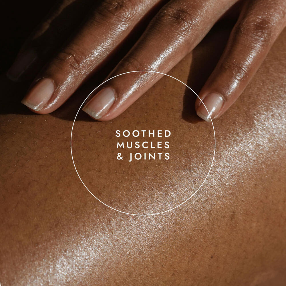 Close-up of a hand touching skin with text 'Soothed Muscles & Joints' in the center.
