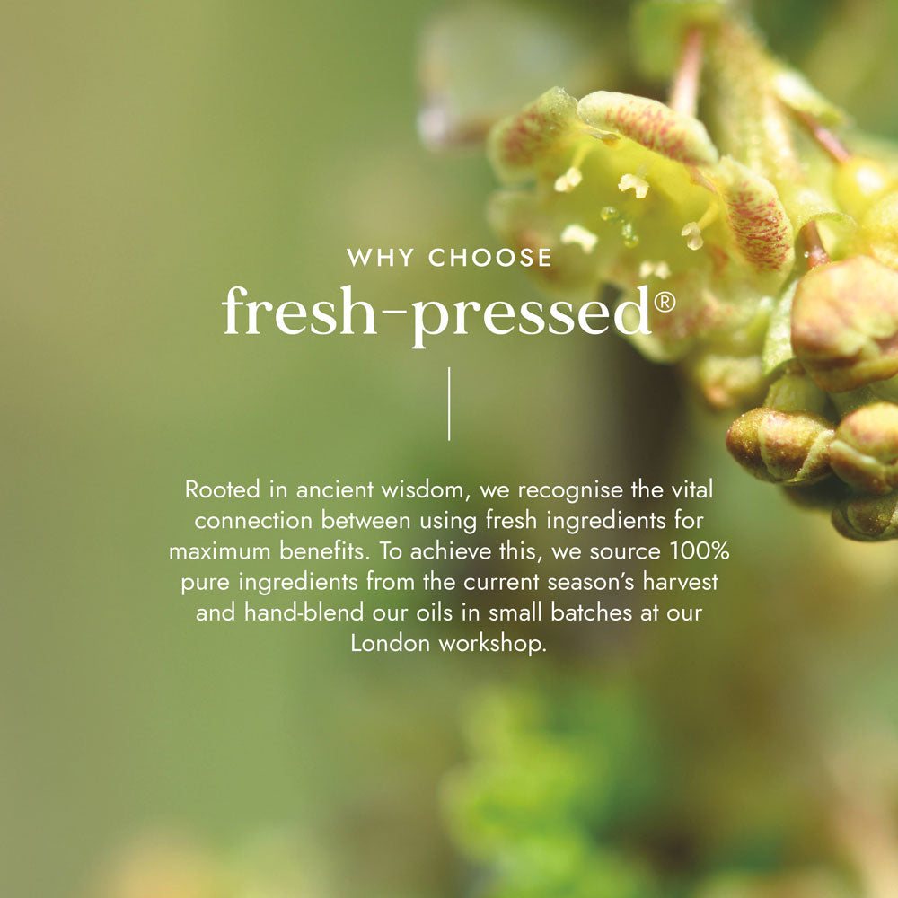 Close-up of green leaves with text about fresh-pressed products on a blurred green background