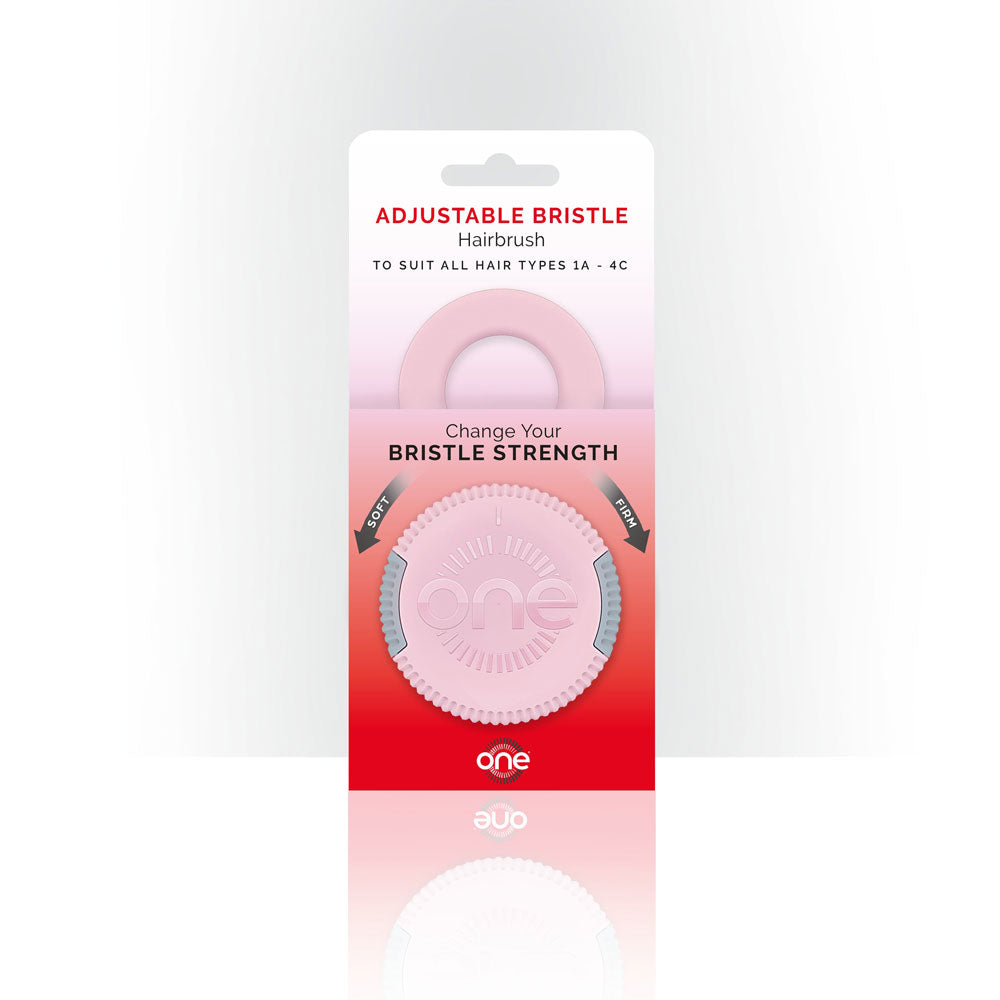 Packaging of an adjustable bristle hairbrush with a pink hairbrush inside on a white background.