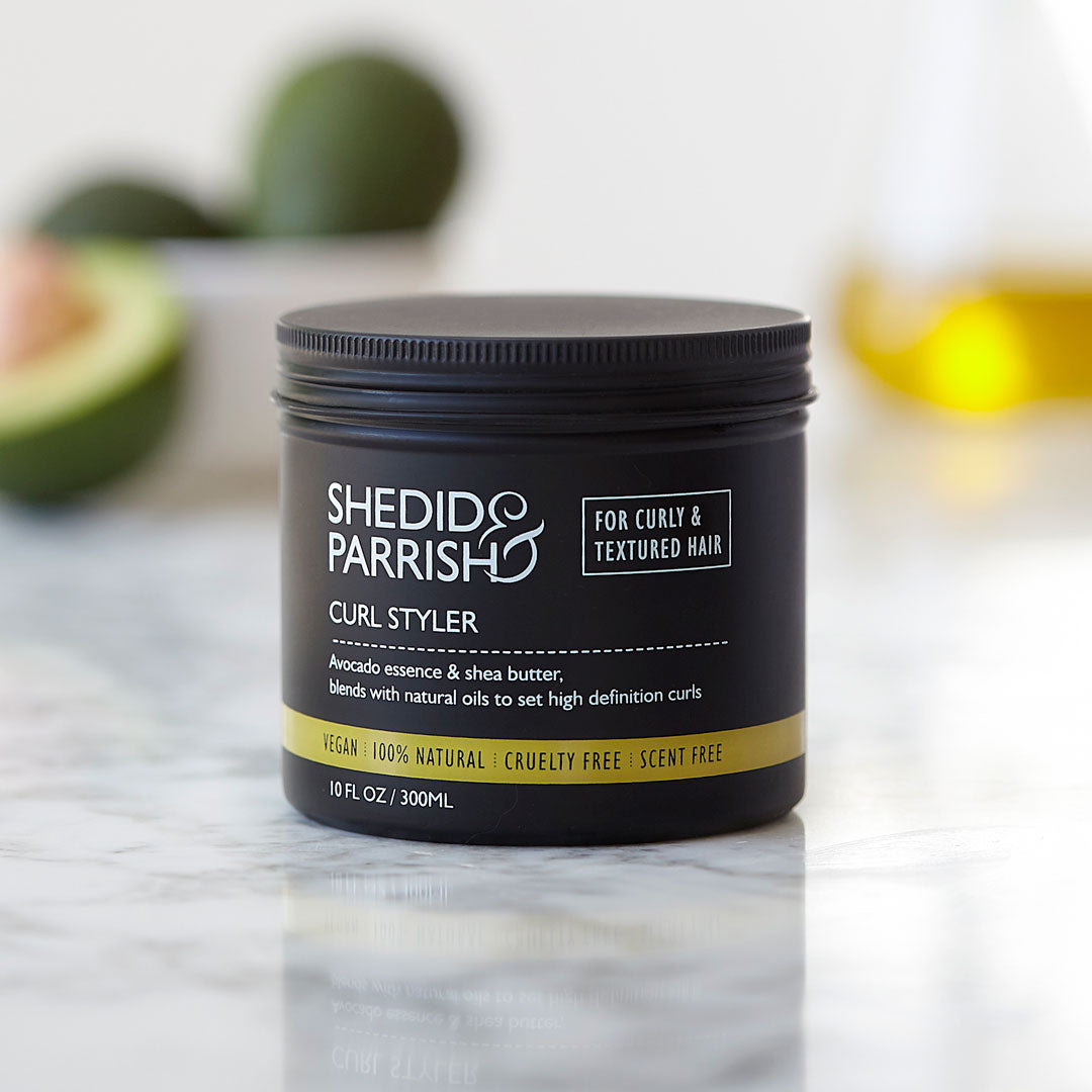 Shedid Parrish Curl Styler jar on a marble surface with avocados in the background