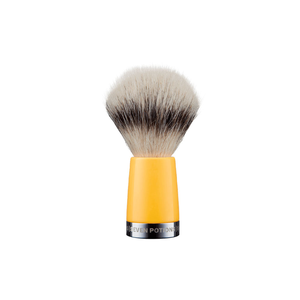Makeup brush with yellow handle and black bristles on a white background