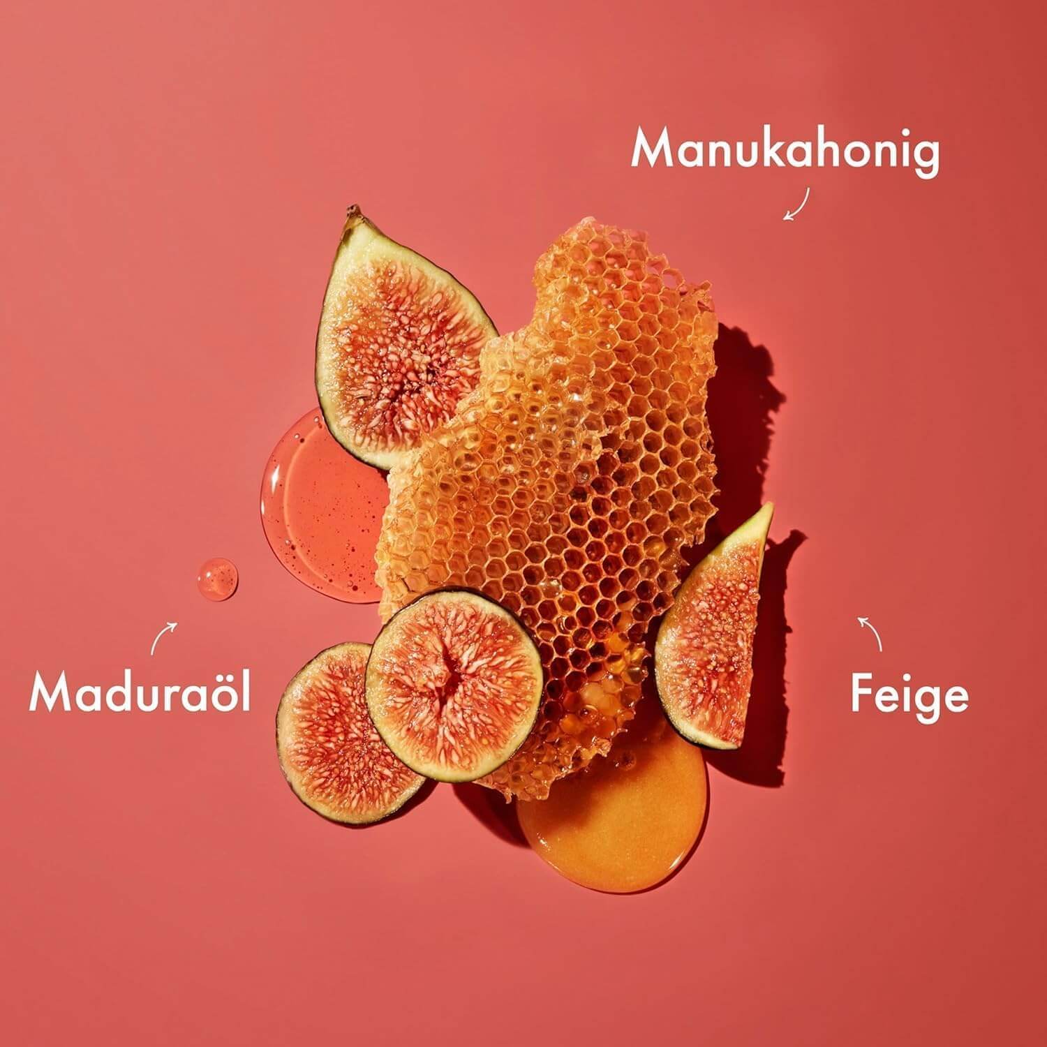 Honeycomb with fig slices on a red background, labeled 'Manukahonig', 'Maduraöl', and 'Feige'.