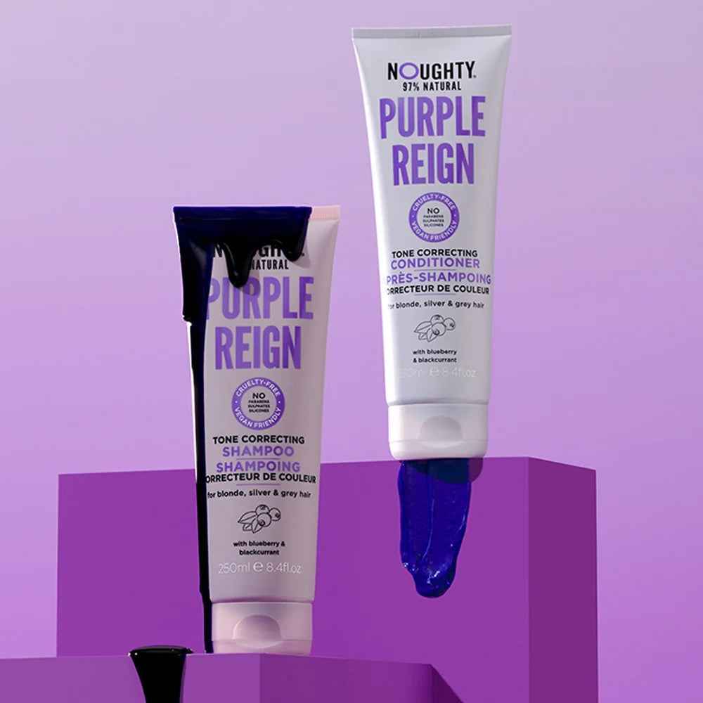 Two bottles of Noughty Purple Reign hair care products on a purple background