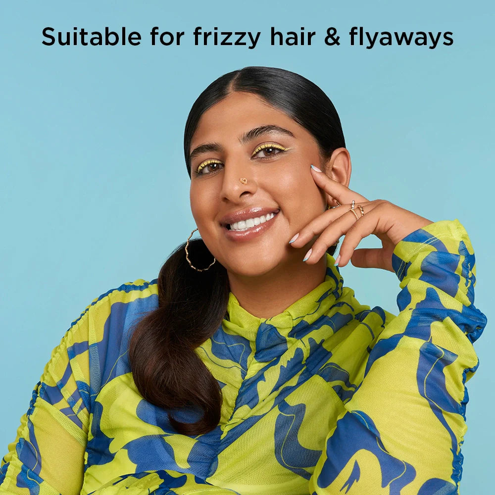 Woman wearing a colorful jacket with text 'Suitable for frizzy hair & flyaways' on a blue background
