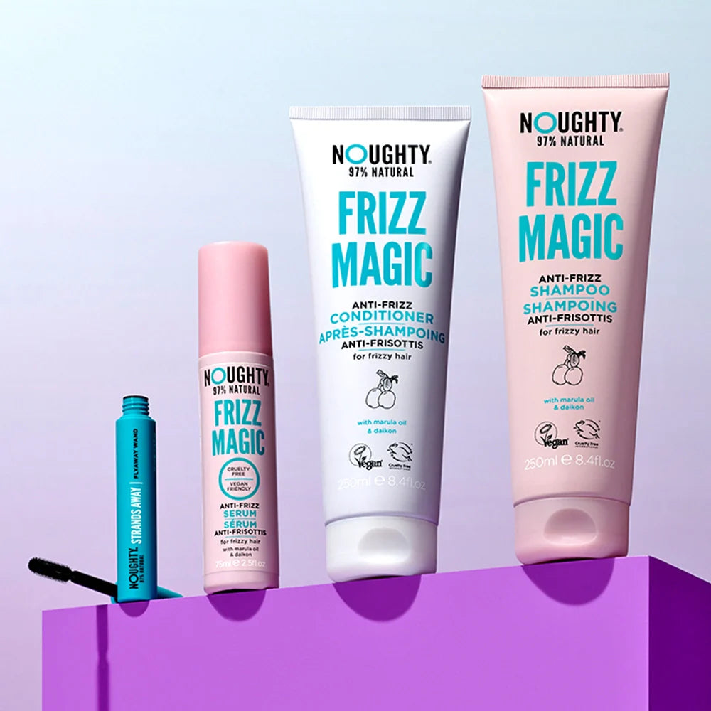 Set of Noughty Frizz Magic hair care products on a purple platform with a light blue background