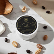 Body butter container with coconut and coffee beans on a marble surface