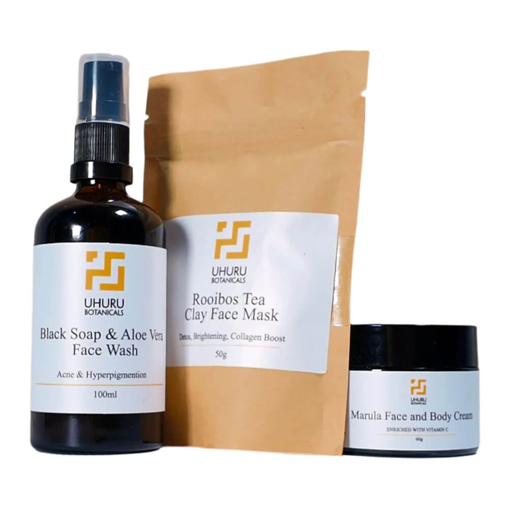 Uhuru Botanics skincare products including a face wash, clay face mask, and cream on a white background.
