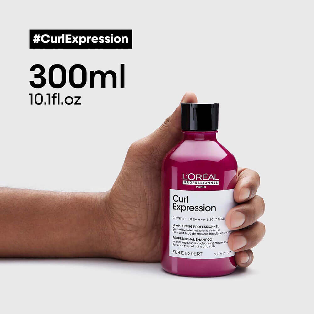 L'Oreal Curl Expression shampoo bottle held by a hand with '#CurlExpression' text and volume information.