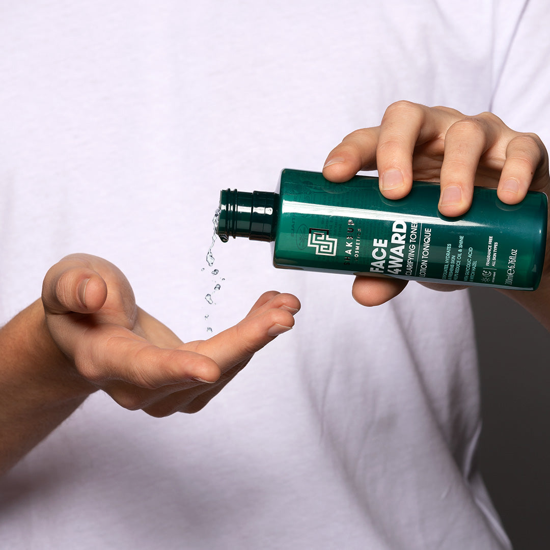 Person holding a green bottle labeled 'Face Award' over another hand with water being poured.