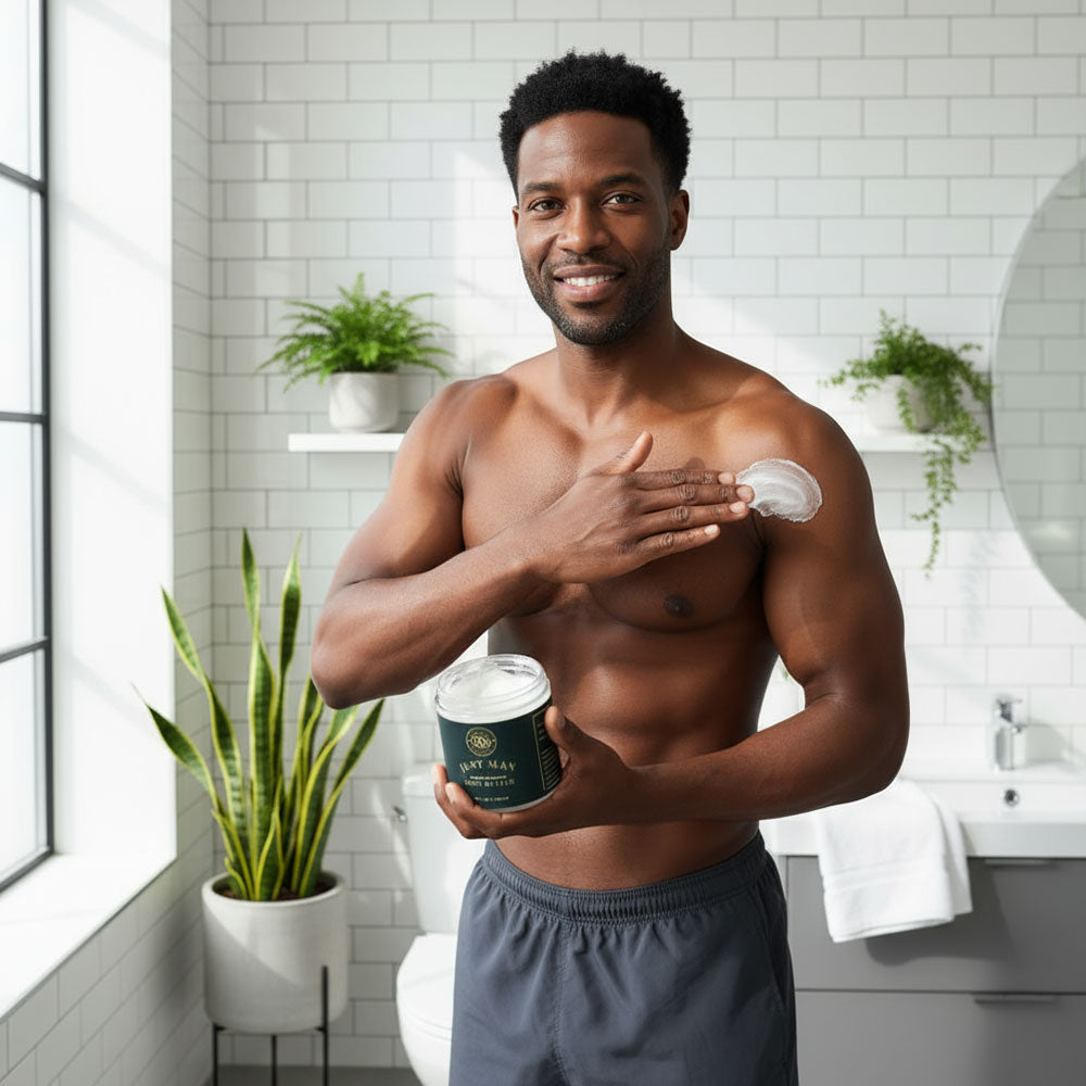 Man applying body lotion in a bathroom