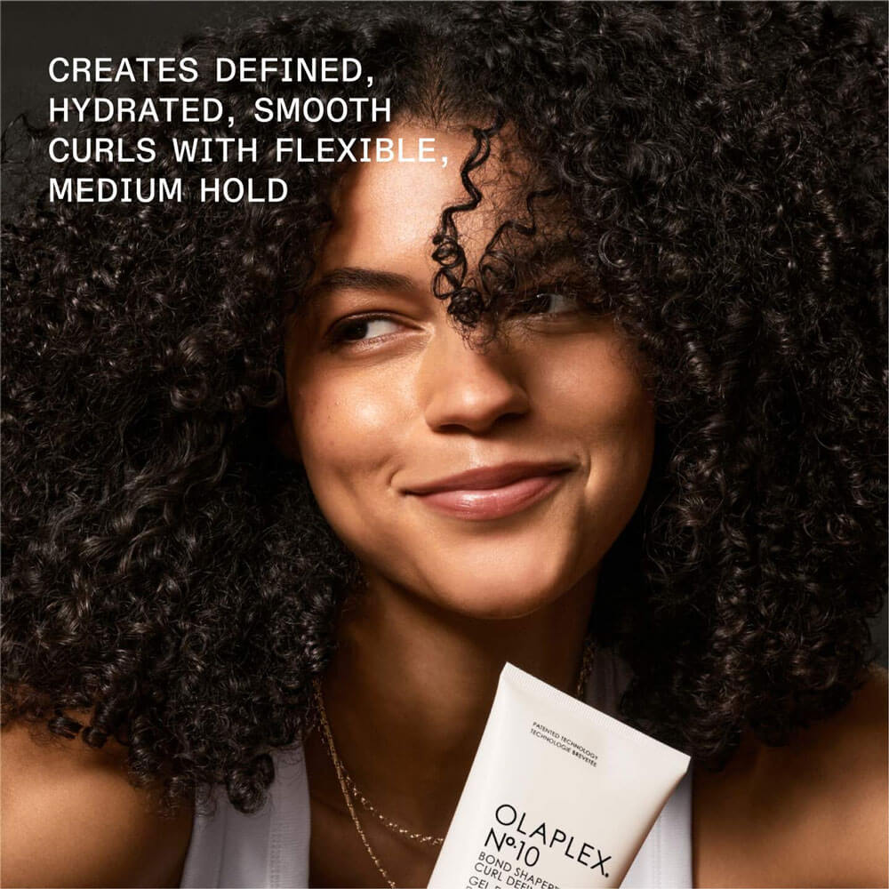 Woman with curly hair holding Olaplex product with text about hair product benefits