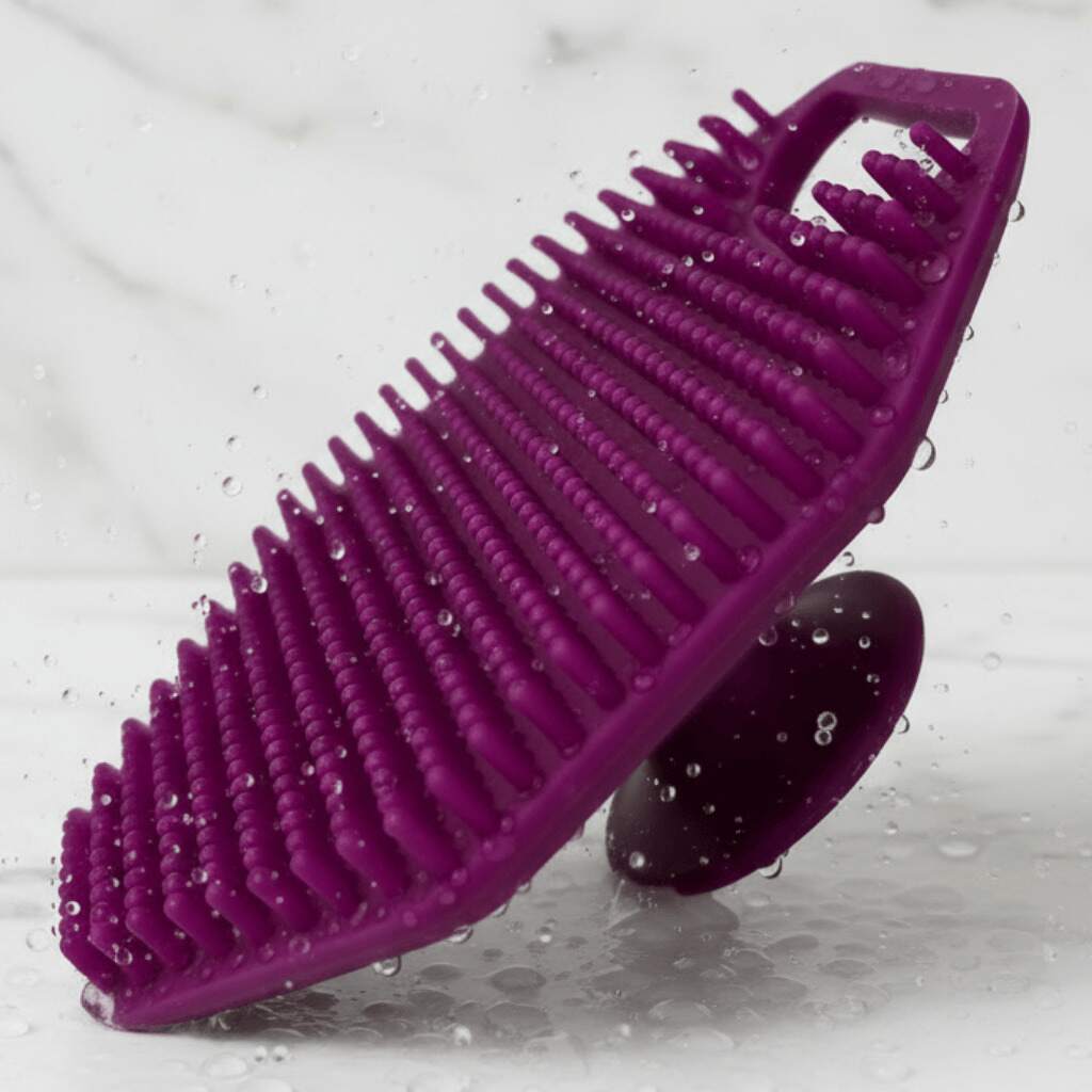 Purple scrubber with textured surface on a gray background